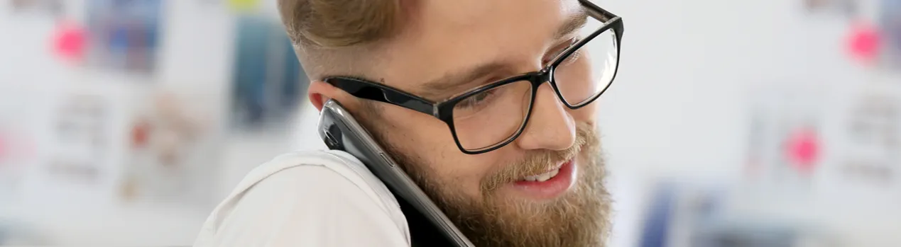 osoba w okularach pracująca przy komputerze w nowoczesnym biurze