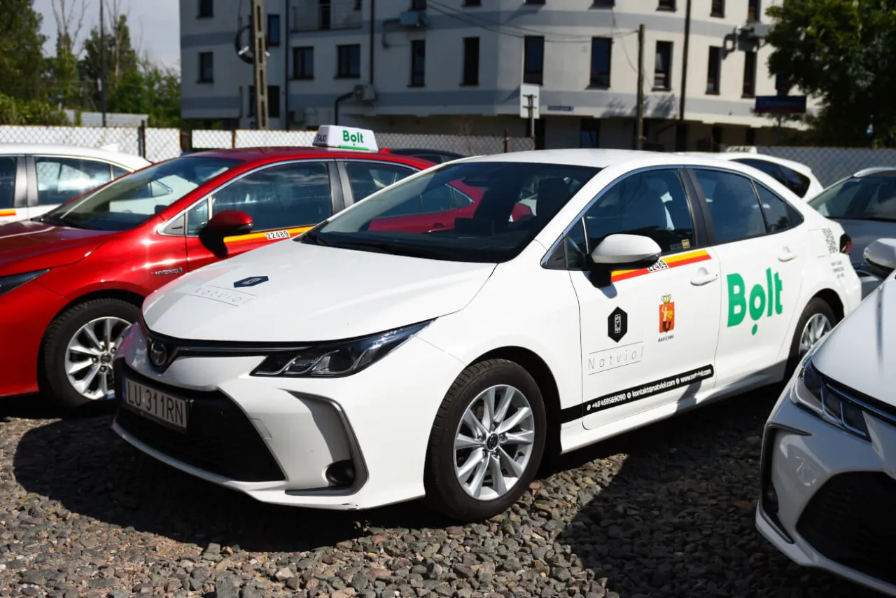 Białe i czerwone samochody z logo Bolt, gotowe do jazdy. Dowiedz się, jak zostać kierowcą Bolta i zacznij zarabiać.