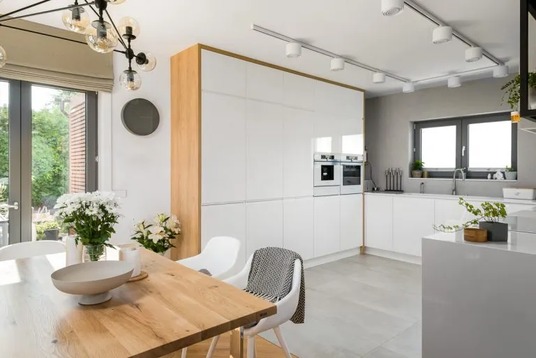 kuchnia białe meble drewniany blat neutralne kolory ścian beż szary biel