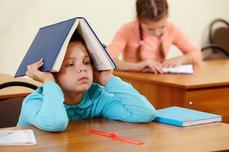 Dziecko smutne w ławce szkolnej, stygmatyzacja w szkole