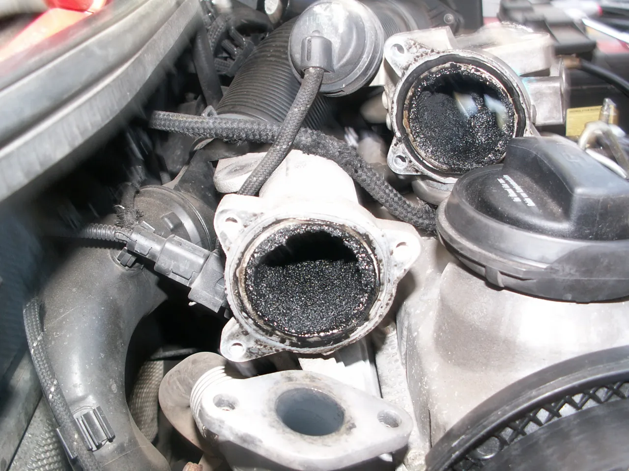 Silnik z nagromadzonym nagarem w układzie EGR. Widoczne zaslepienie egr i zanieczyszczone elementy.