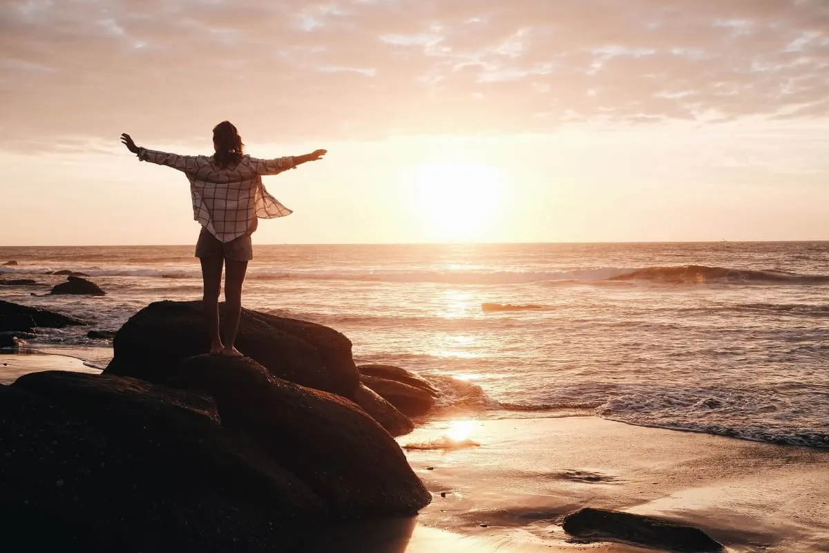 Osoba wspinająca się na g&oacute;rę symbolizująca motywację i dążenie do celu
