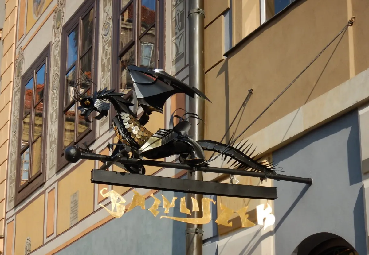 Metalowy bazyliszek zdobi fasadę kamienicy. To jakby żywa legenda o bazyliszku dla dzieci, która zaprasza do niezwykłej przygody.