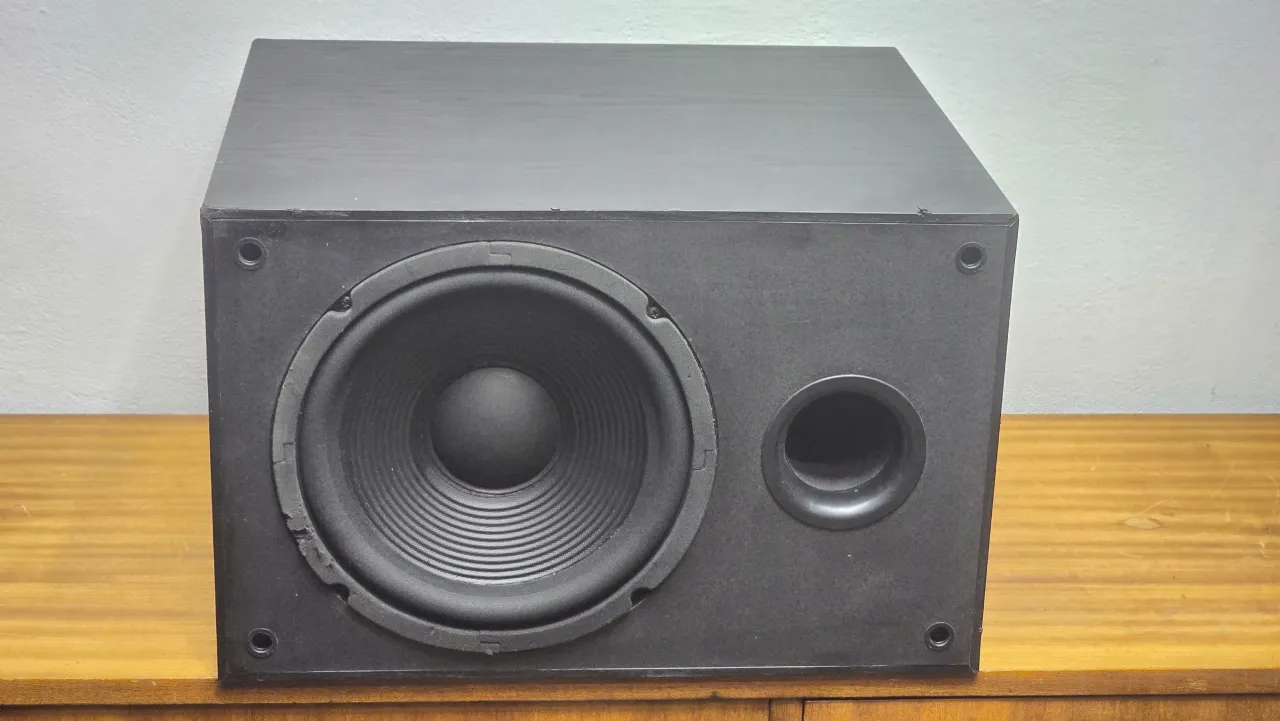 Czarny, aktywny jbl subwoofer estradowy z widocznym portem bass reflex i membraną.