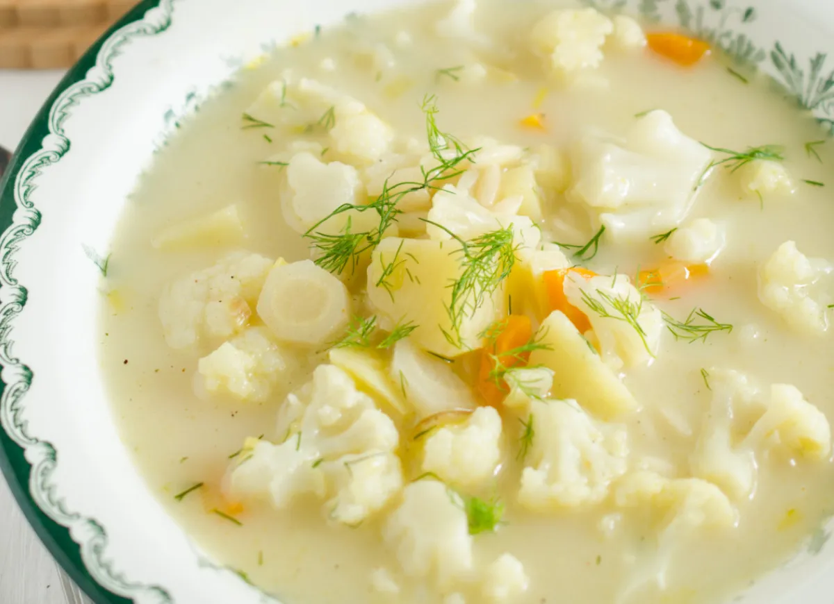 Kremowa zupa z kalafiorem, ziemniakami i marchewką, posypana świeżym koperkiem. Idealna, gdy zastanawiasz się, ile gotuje się kalafior w zupie.