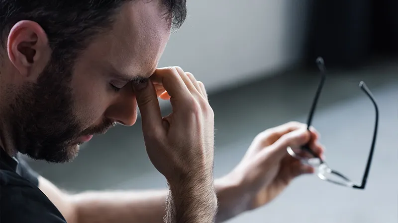 osoba patrząca na wiele ekranów, zmęczone oczy