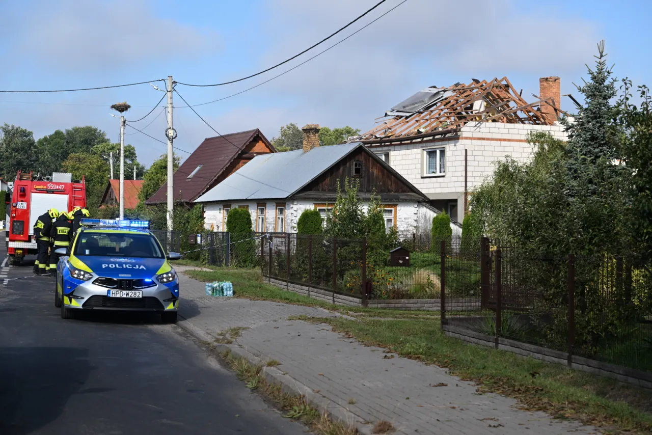 Policja i straż pożarna na miejscu zdarzenia. Zniszczony dach domu, jak po wojnie. Ubezpieczenie na wypadek wojny to dziś ważna sprawa.