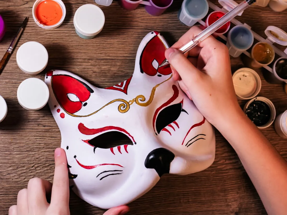 Ręcznie malowana maska karnawałowa w kształcie lisa, tworzona z farbkami. Jak zrobić maskę karnawałową? To proste!