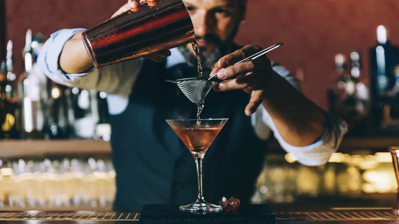 barman w pracy przygotowujący koktajl