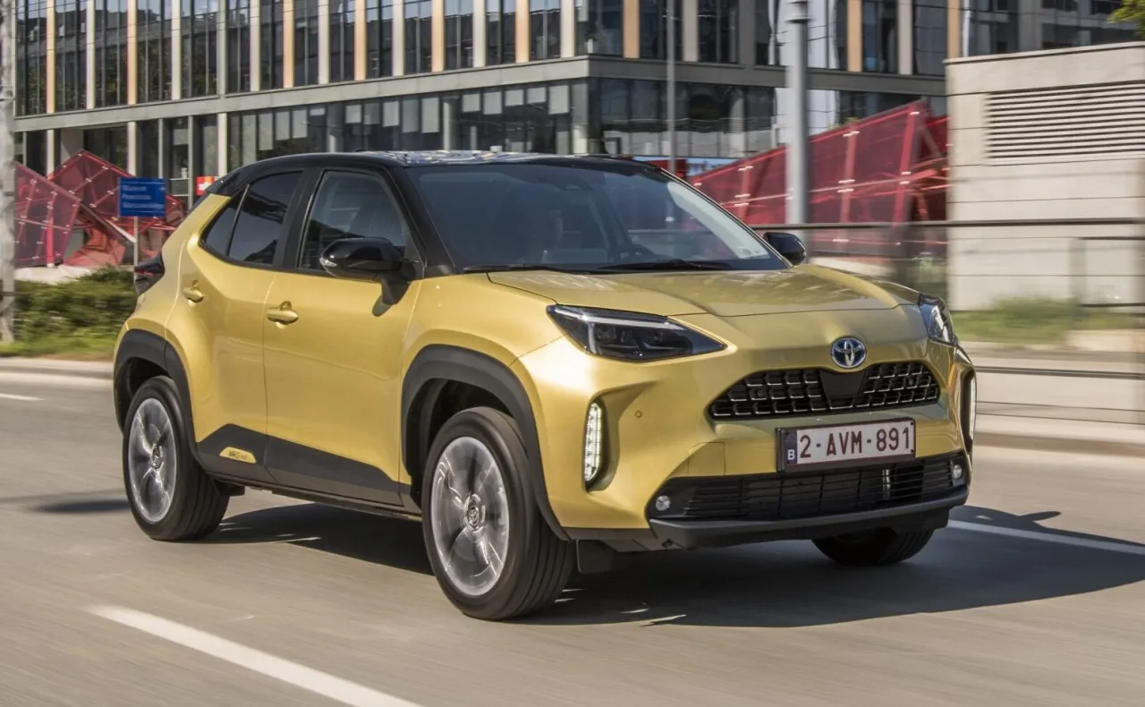 Złota Toyota Yaris Cross Hybrid w ruchu miejskim. Zastanawiasz się, ile pali Toyota Yaris Hybrid? Ten model zachwyca niskim spalaniem.