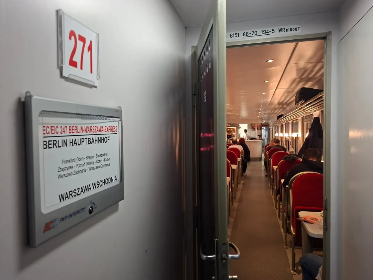 Wnętrze wagonu EC/EIC 247 Berlin-Warszawa-Express. Widać rząd czerwonych siedzeń i stoliki.