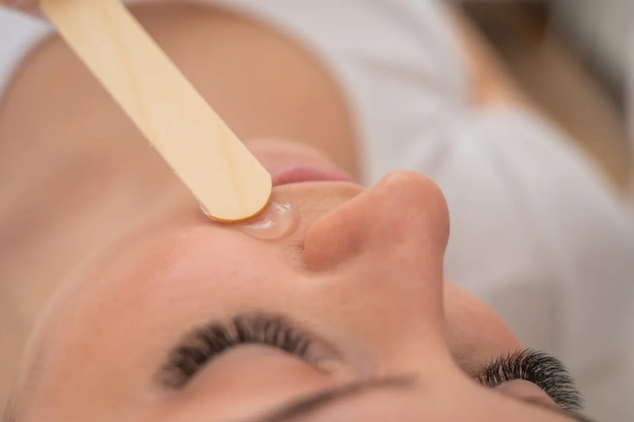 kobieta usuwająca wąsik w domu