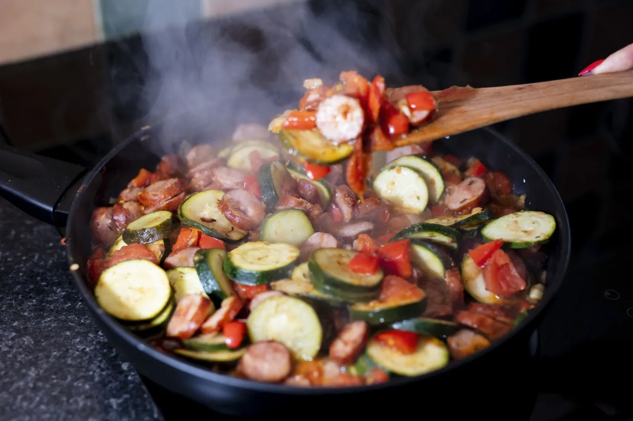 Gorące leczo z kiełbasą, cukinią i papryką paruje na patelni. Zastanawiasz się, jakie przyprawy do leczo dodasz, by było idealne?