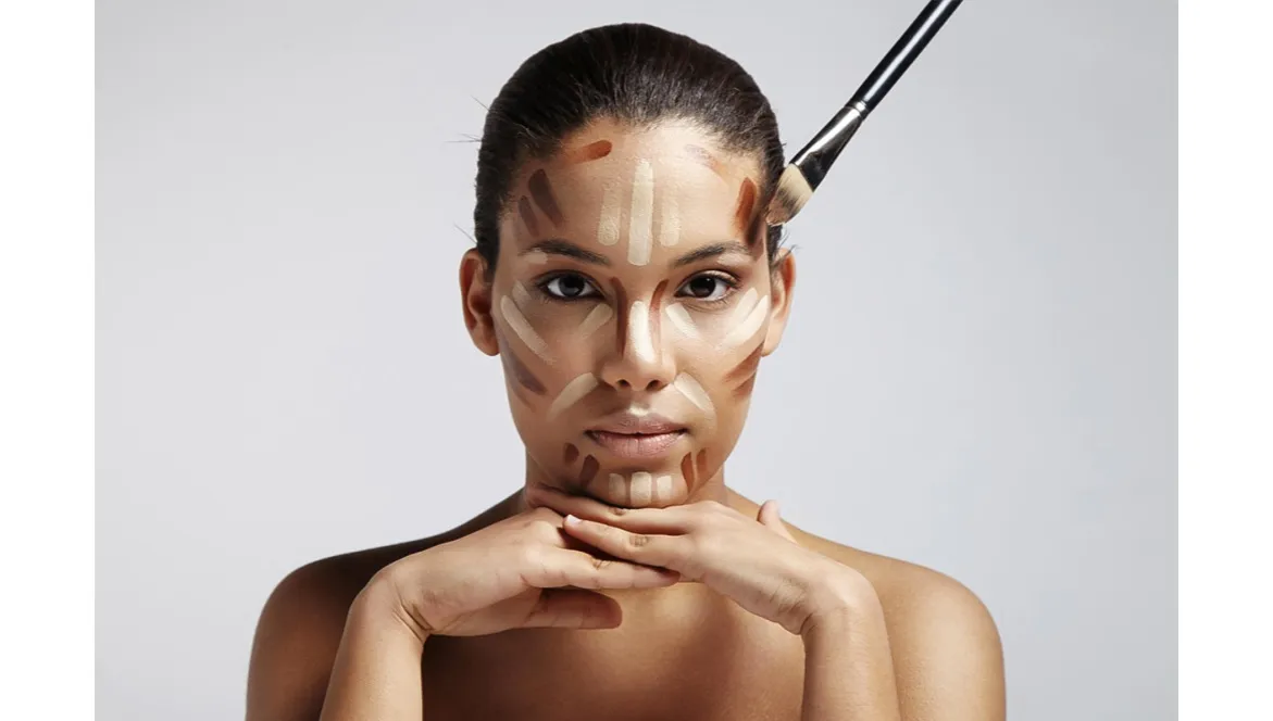 kobieta nakłada podkład na twarz pędzlem