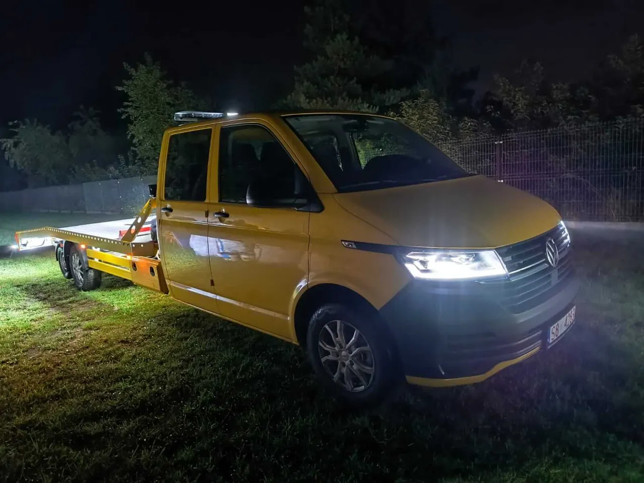 Ż&oacute;łty laweta nocą, gotowa do pomocy. Ubezpieczenie assistance co to? To spok&oacute;j na drodze, gdy potrzebujesz wsparcia.