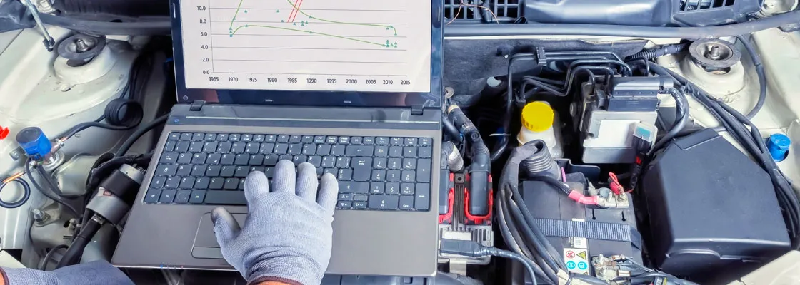 Mechanik podłącza komputer do samochodu diagnostyka DPF