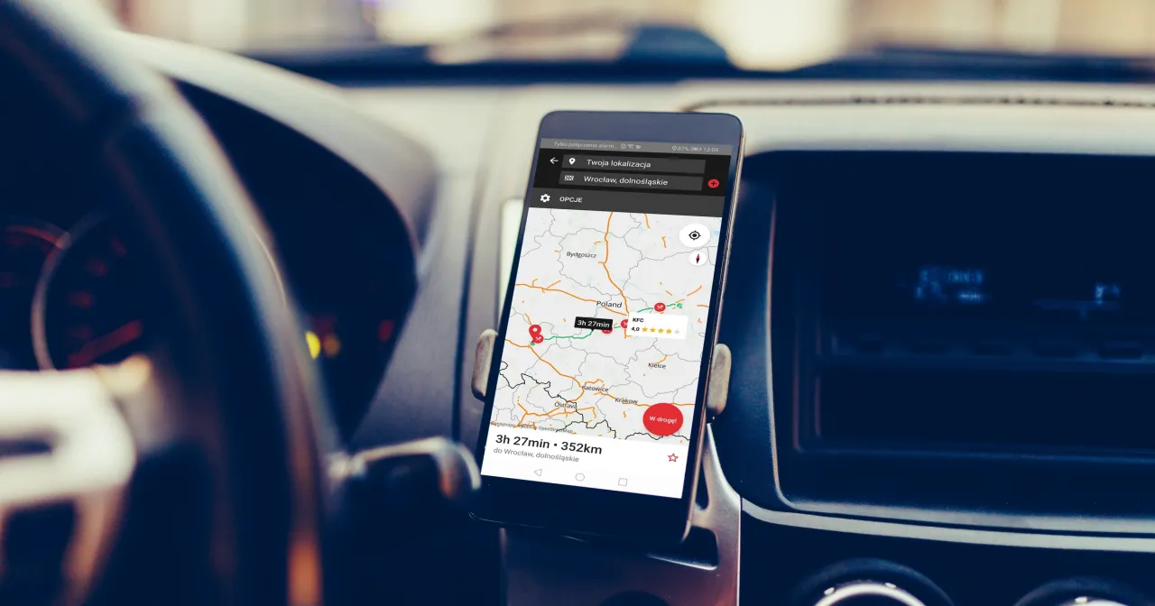 Telefon z mapą Yanosik w uchwycie samochodowym. Aplikacja pokazuje trasę do Wrocławia, dolnośląskie. Jak pobrać aplikację Yanosik na telefon?