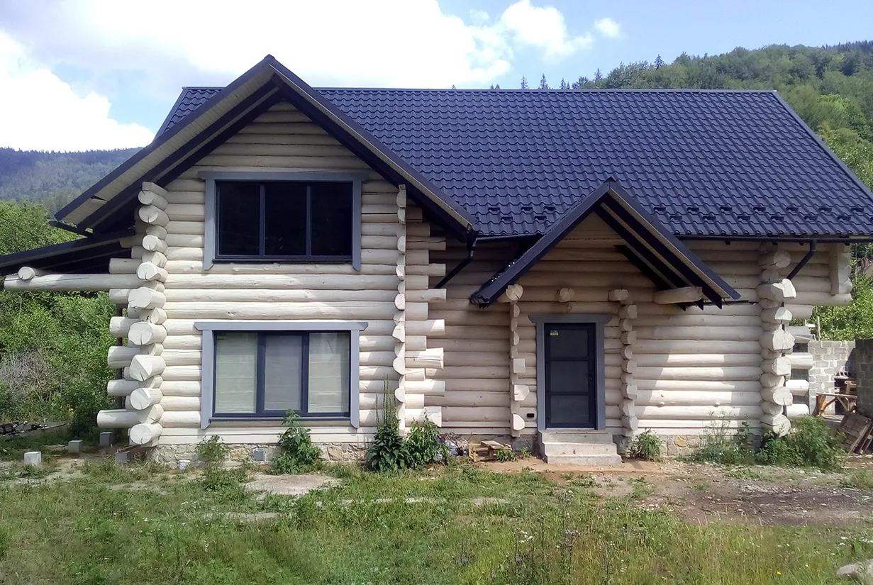 Drewniany dom z bali czy murowany? Koszty budowy mogą się różnić, ale ten dom z bali wygląda przytulnie.