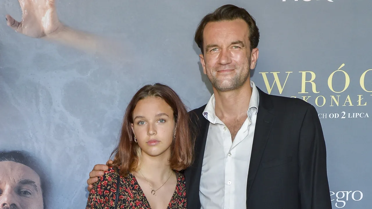 Mężczyzna i młoda kobieta pozują na tle, gdzie widać fragment dłoni w wielkiej wodzie. Może to kot, który się kąpie?