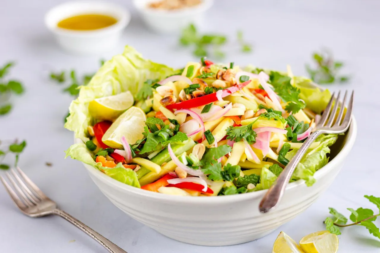 Kolorowa tajska sałatka z mango z Kuchennych Rewolucji, pełna świeżych zi&oacute;ł, orzeszk&oacute;w ziemnych i limonki.