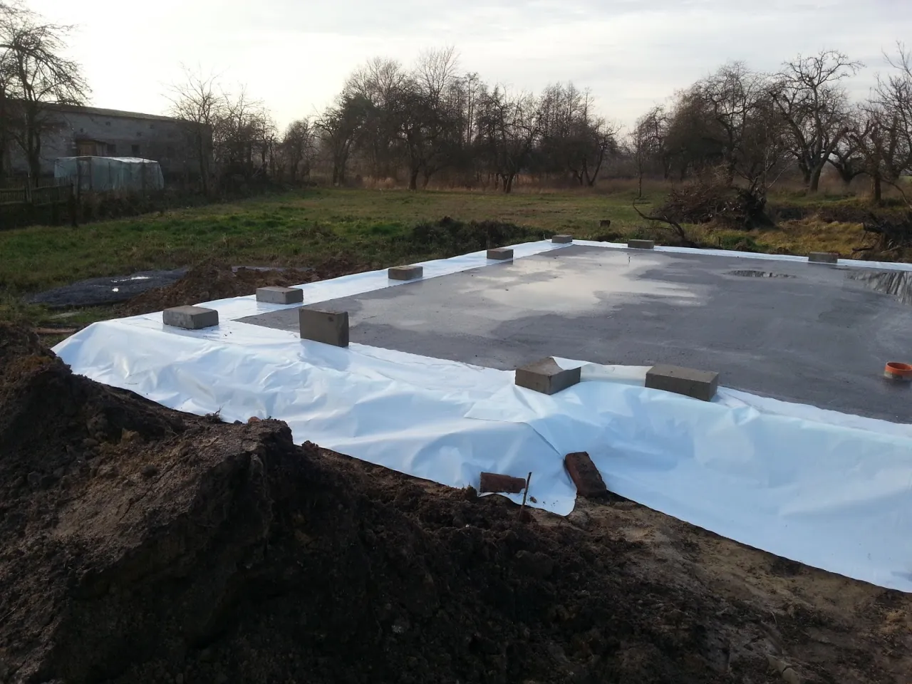 Fundamenty przykryte folią, zabezpieczone przed zimą. Czy można zostawić odkryte fundamenty na zimę? Tak, jeśli są odpowiednio zabezpieczone.