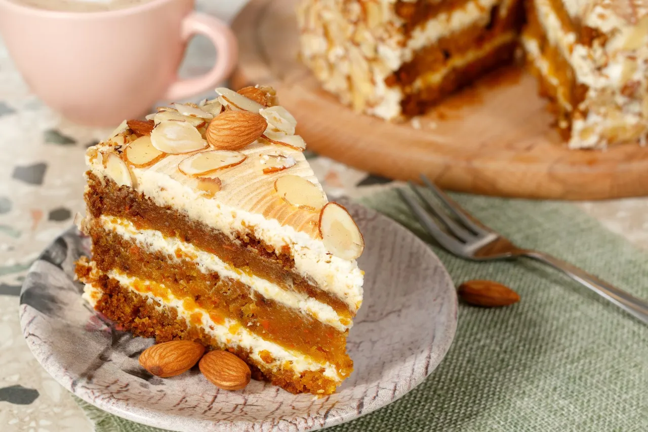 Pyszny kawałek ciasta marchewkowego z kremem i migdałami. Idealny przepis na zdrowe ciasto, które zachwyci każdego.