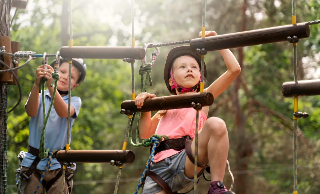 dzieci bawiące się w parku linowym w górach