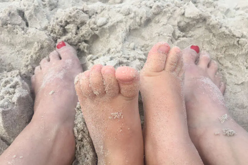 Dziecko mierzące stopę na kartce przy ścianie