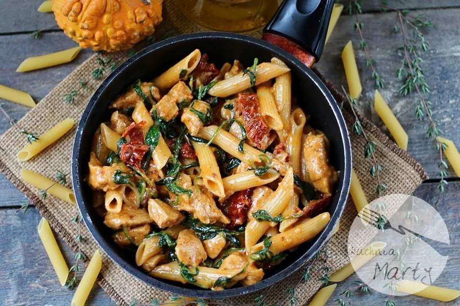 smaczny makaron z kurczakiem i szpinakiem na patelni
