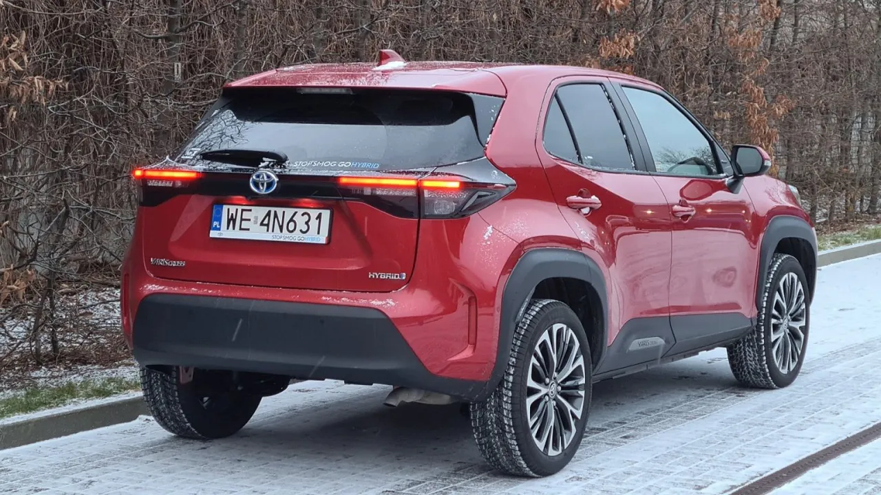 Czerwony Toyota Yaris Cross Hybrid na śniegu. Zastanawiasz się, ile kosztuje Toyota Yaris Hybrid? Ten model wygląda świetnie!