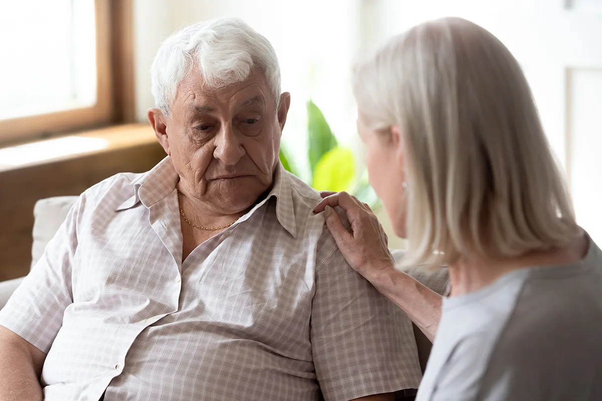 Starsza osoba z opiekunem w spokojnym otoczeniu