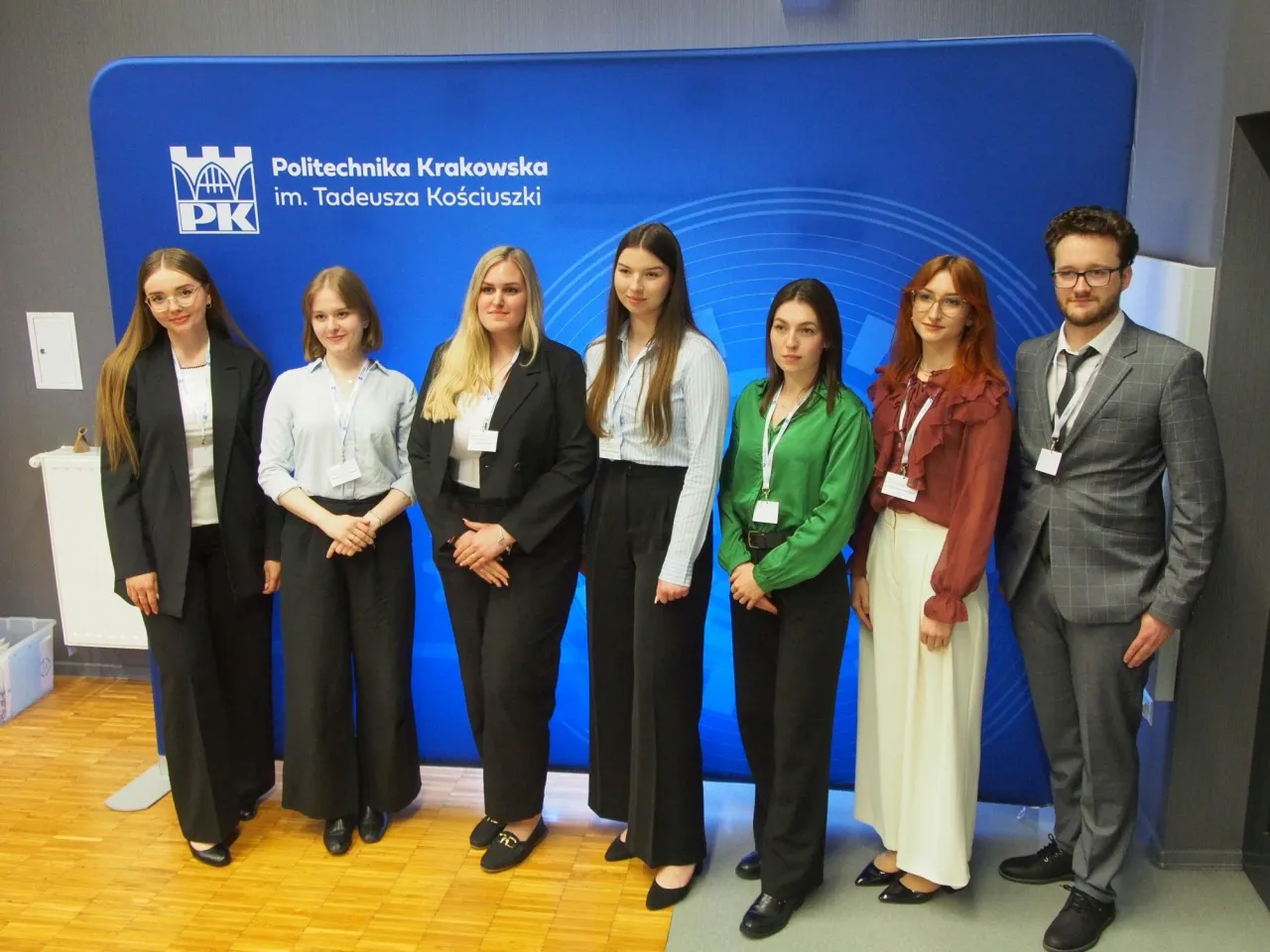 Grupa studentów na tle Politechniki Krakowskiej. Starosta na studiach, jak widać, dba o profesjonalny wizerunek.