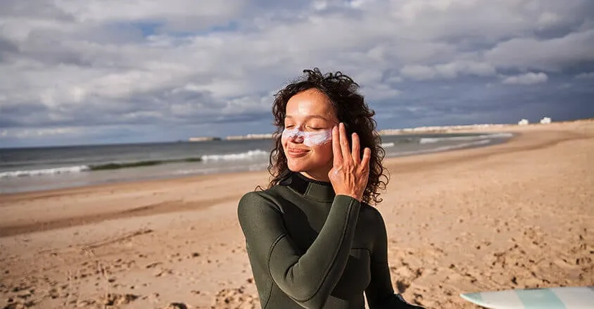 kobieta aplikująca krem z filtrem SPF na twarz