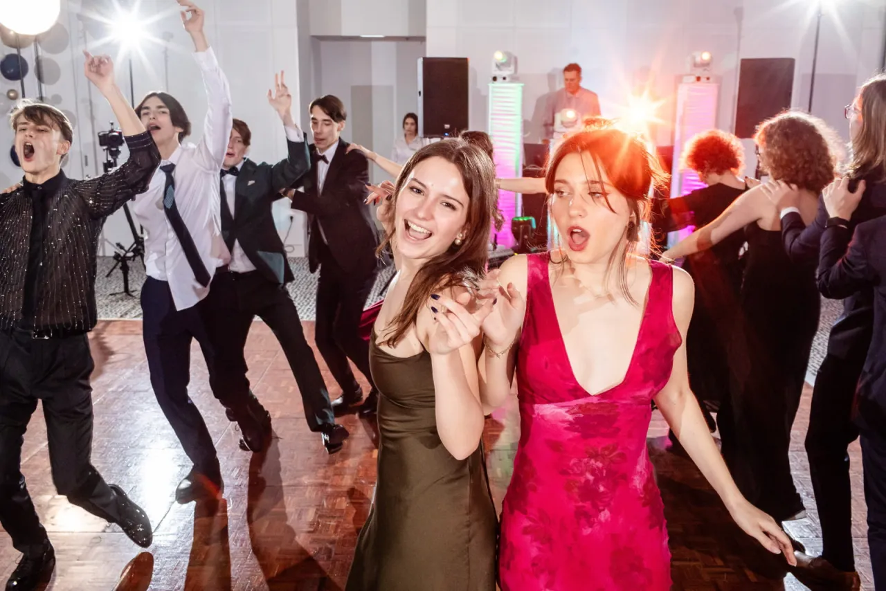 Fotograf na studniówce robiący zdjęcia grupie młodzieży