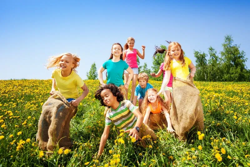 dzieci i rodzice skaczący w workach
