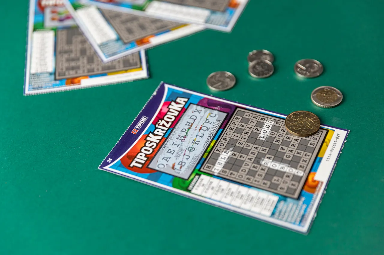 Kilka zdrapek i monet na zielonym tle. Zbliżenie na jedną zdrapkę, kt&oacute;ra pokazuje, jak grać w zdrapki, z polami do zdrapania i siatką liter.