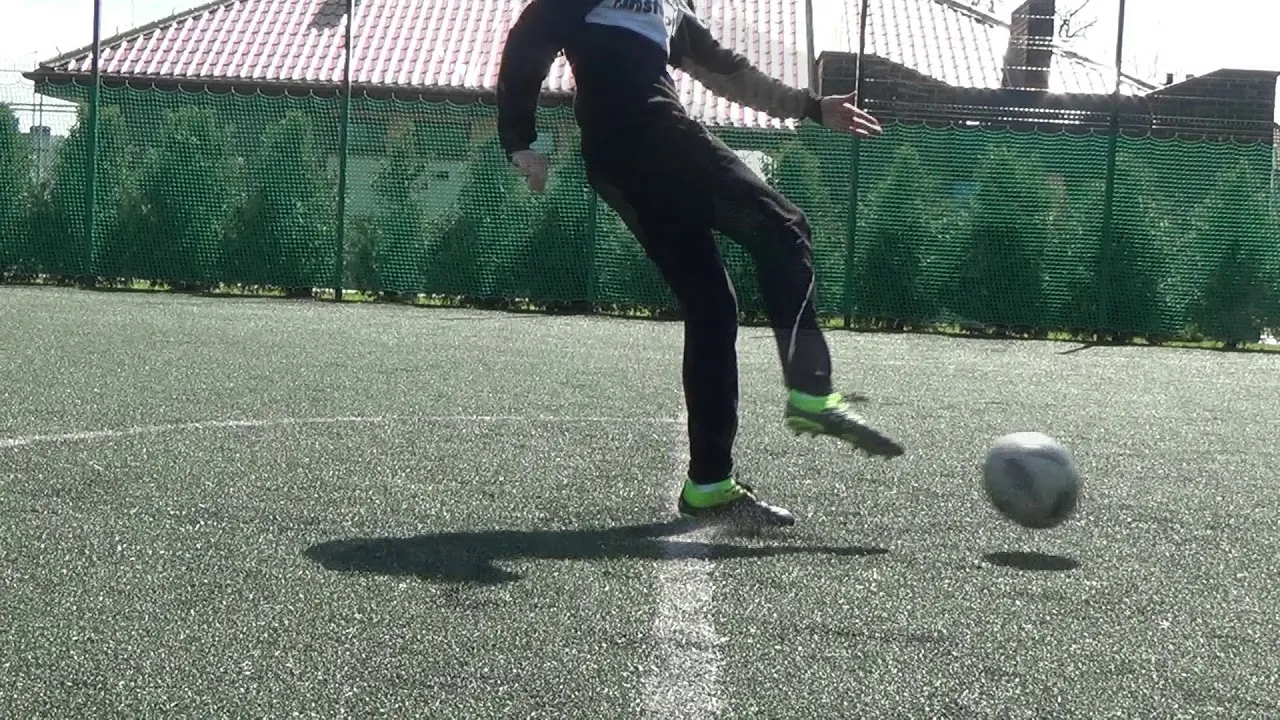 Piłkarz uderzający piłkę prostym podbiciem