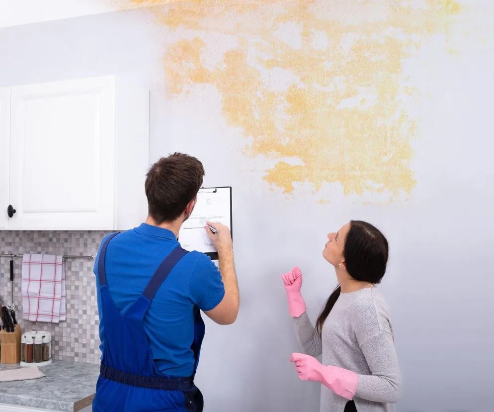 Sąsiad rozmawia z poszkodowanym po zalaniu mieszkania