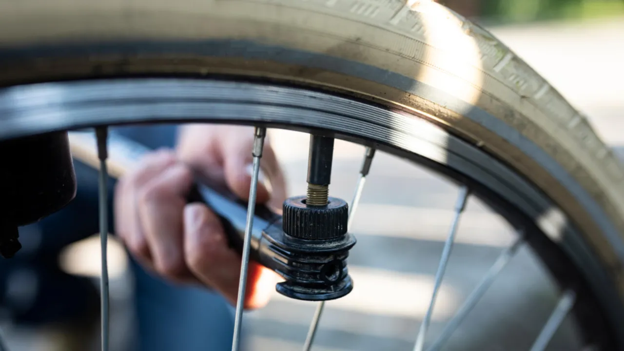 Rowerzysta pompujący oponę rowerową