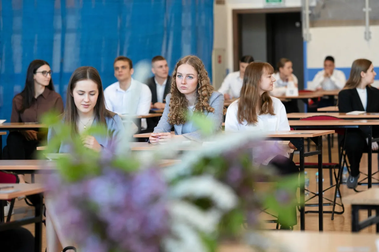 Młodzi ludzie świętujący po zdanej maturze