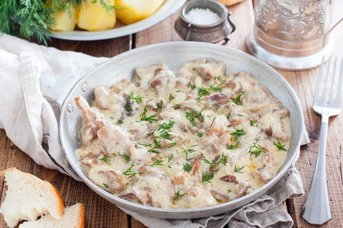 Grzyby w śmietanie, ozdobione koperkiem, kuszą aromatem. Idealne przyprawy do grzybów w śmietanie podkreślą ich smak. Obok kromki chleba i ziemniaki.