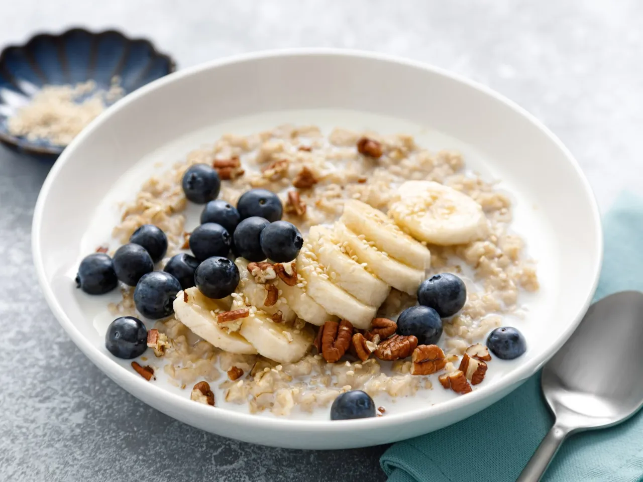 Miska owsianki z mlekiem, jagodami, bananem i orzechami. Zastanawiasz się, ile kalorii ma miska płatków z mlekiem? To zdrowe śniadanie.