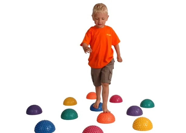 dziecko ćwiczy równowagę na półkulach sensorycznych