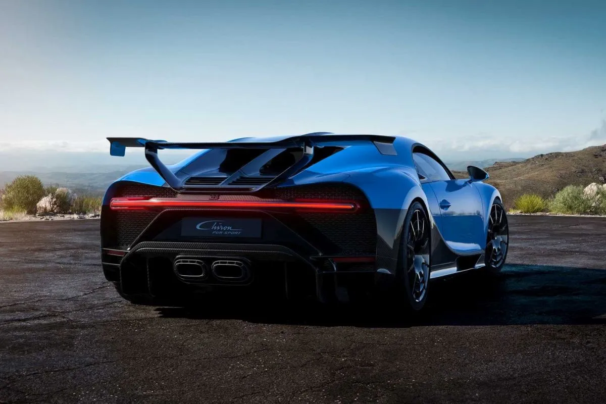 Niebieski Bugatti Chiron Pur Sport z masywnym skrzydłem i czterema końc&oacute;wkami wydechu. Zastanawiasz się, ile kosztuje Bugatti Chiron?
