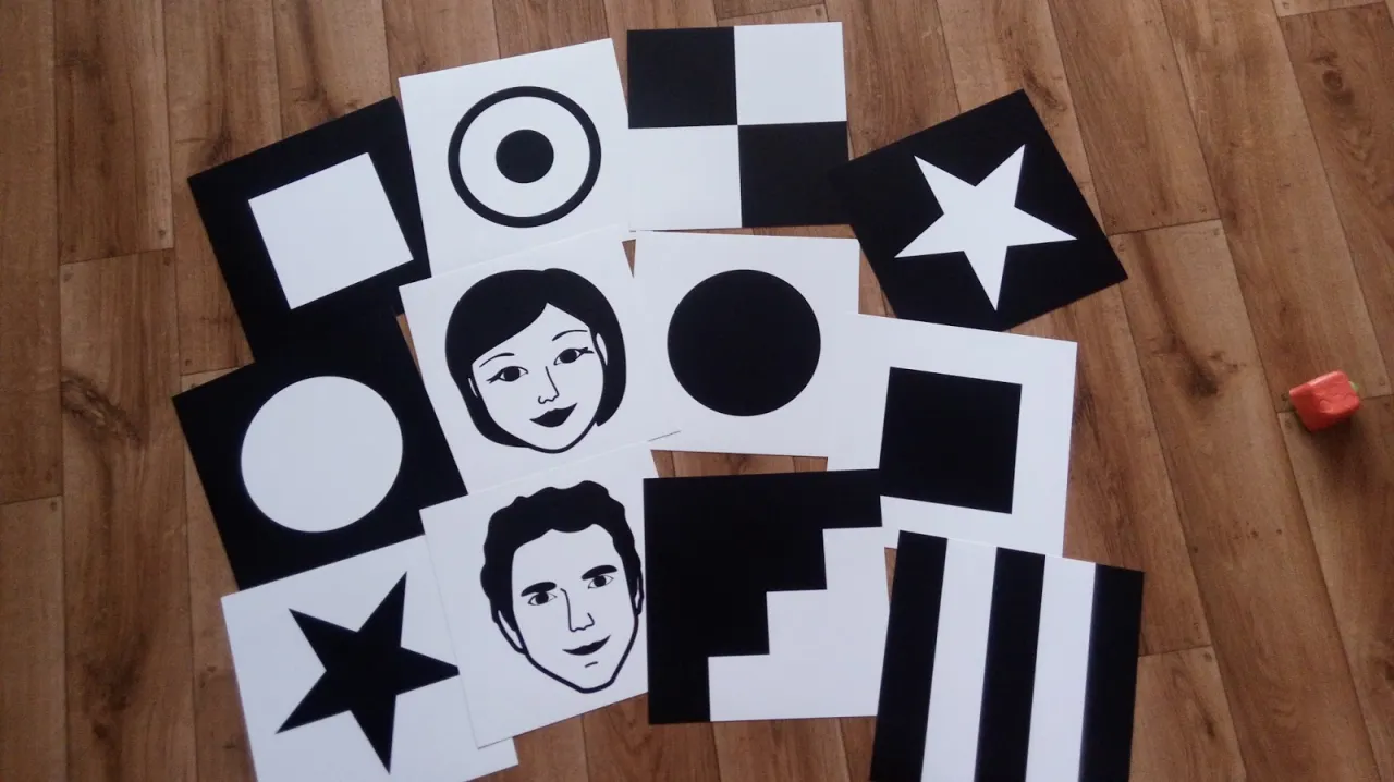 Miesięczne dziecko patrzy na czarno-białe karty kontrastowe