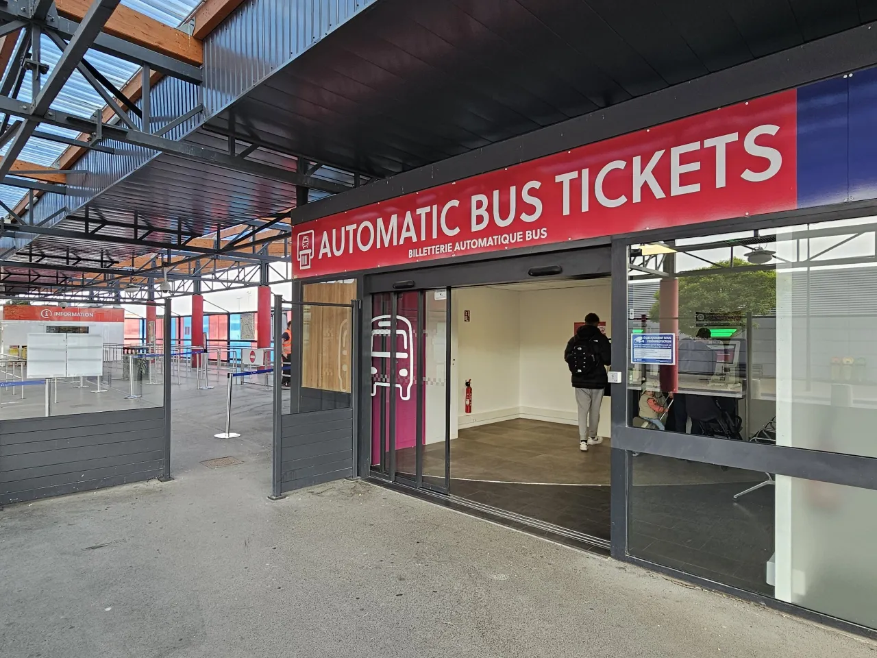Wejście do punktu sprzedaży biletów autobusowych na lotnisku Paryż Beauvais. Osoba wchodzi do środka.
