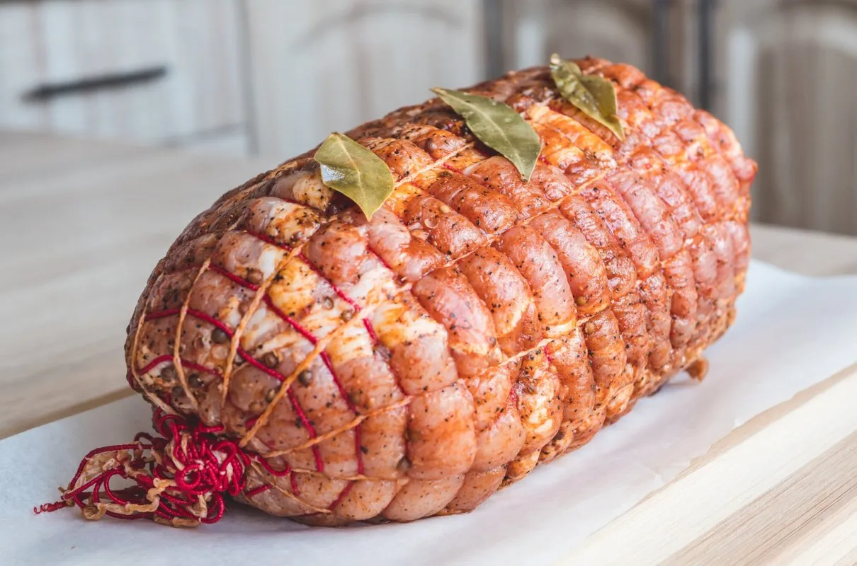 Gotowe do pieczenia roladki z szynki wieprzowej, doprawione i związane sznurkiem. Idealne pytanie: co ugotować z szynki wieprzowej?