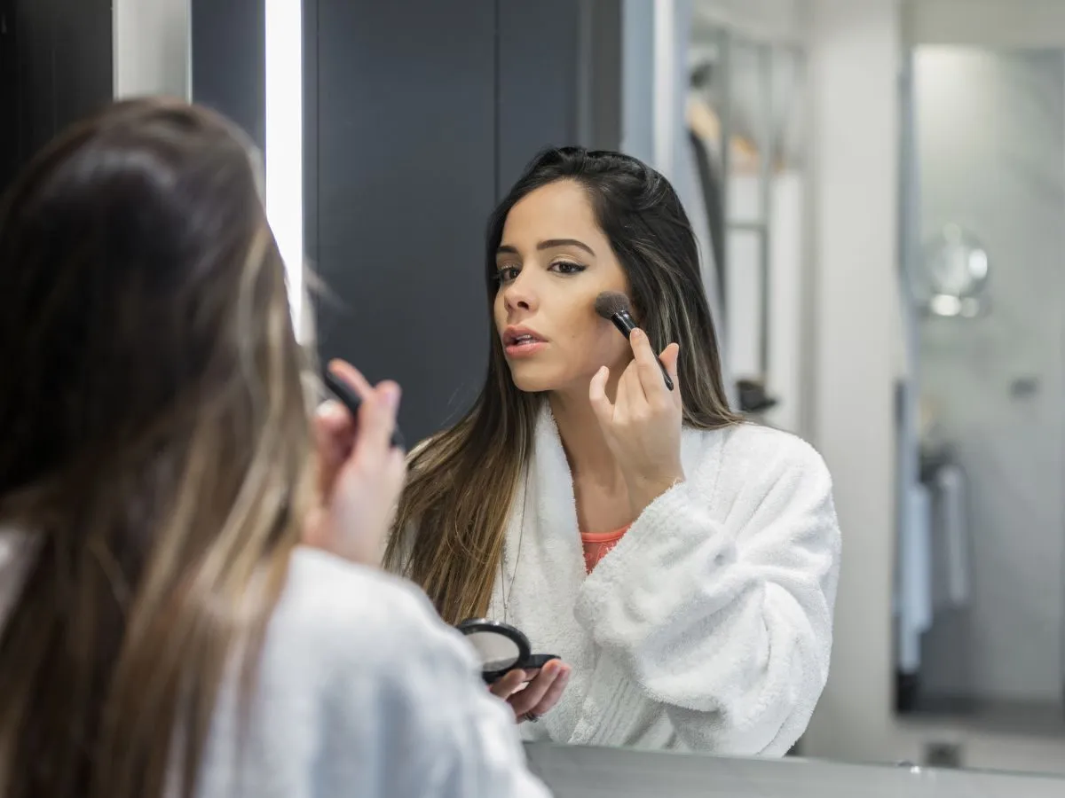 kobieta pudrująca twarz transparentnym pudrem