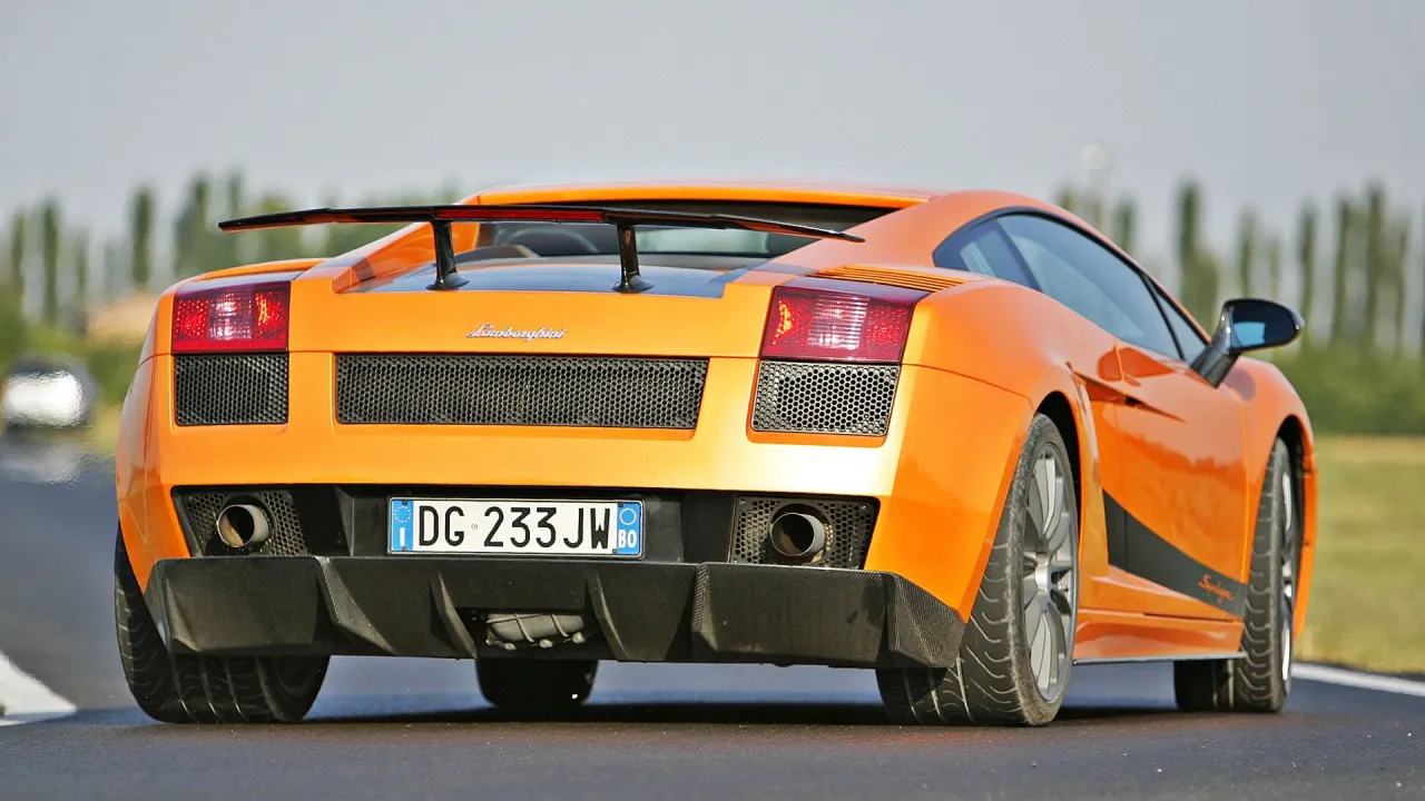 Pomarańczowe Lamborghini Gallardo na torze. Zastanawiasz się, ile kosztuje najtańsze Lamborghini? Ten model to marzenie wielu.