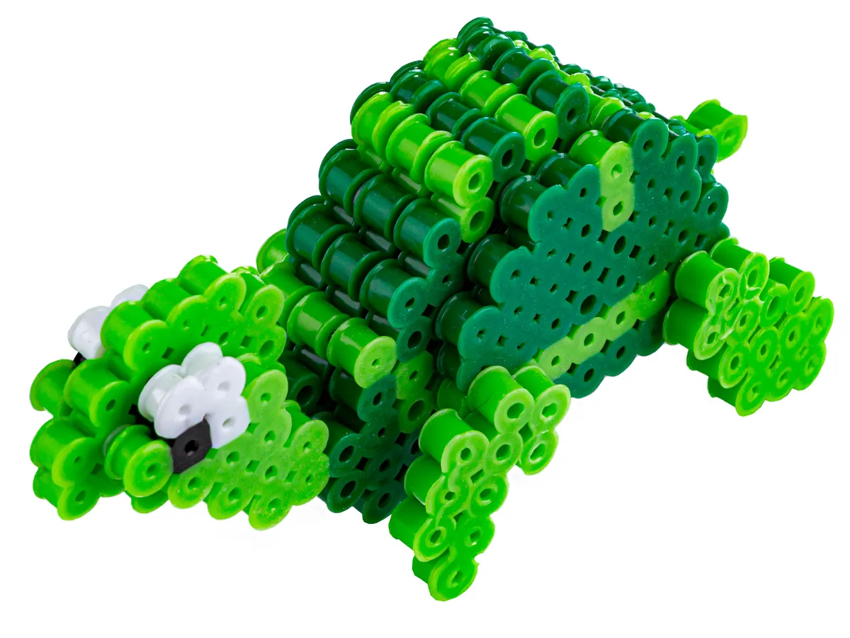 Zielony, tr&oacute;jwymiarowy dinozaur z koralik&oacute;w, jeden z wielu wzor&oacute;w zwierzątek z koralik&oacute;w.